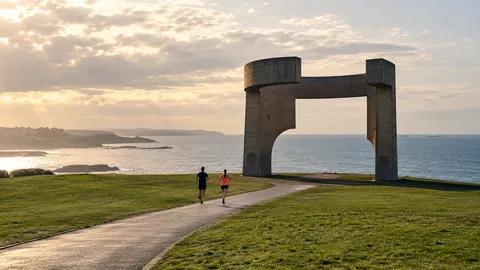 Recreación editorial fotorrealista de KROONA para MBA Media Maratón Gijón Villa de Jovellanos, inspirada en Gijón